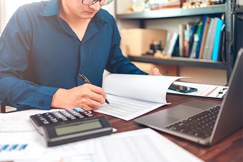Accounting woking with data sheet on the office desk. Calculator with accounting report and financial statement on desk.