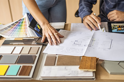 Close up of a architect discussing building blueprints with female colleague in office