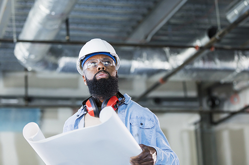African American construction worker with plans