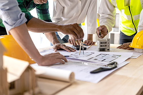 Engineers work as a team with blueprints for architectural plans. Engineer sketching construction project concept with architect equipment Architect and foreman talking at table